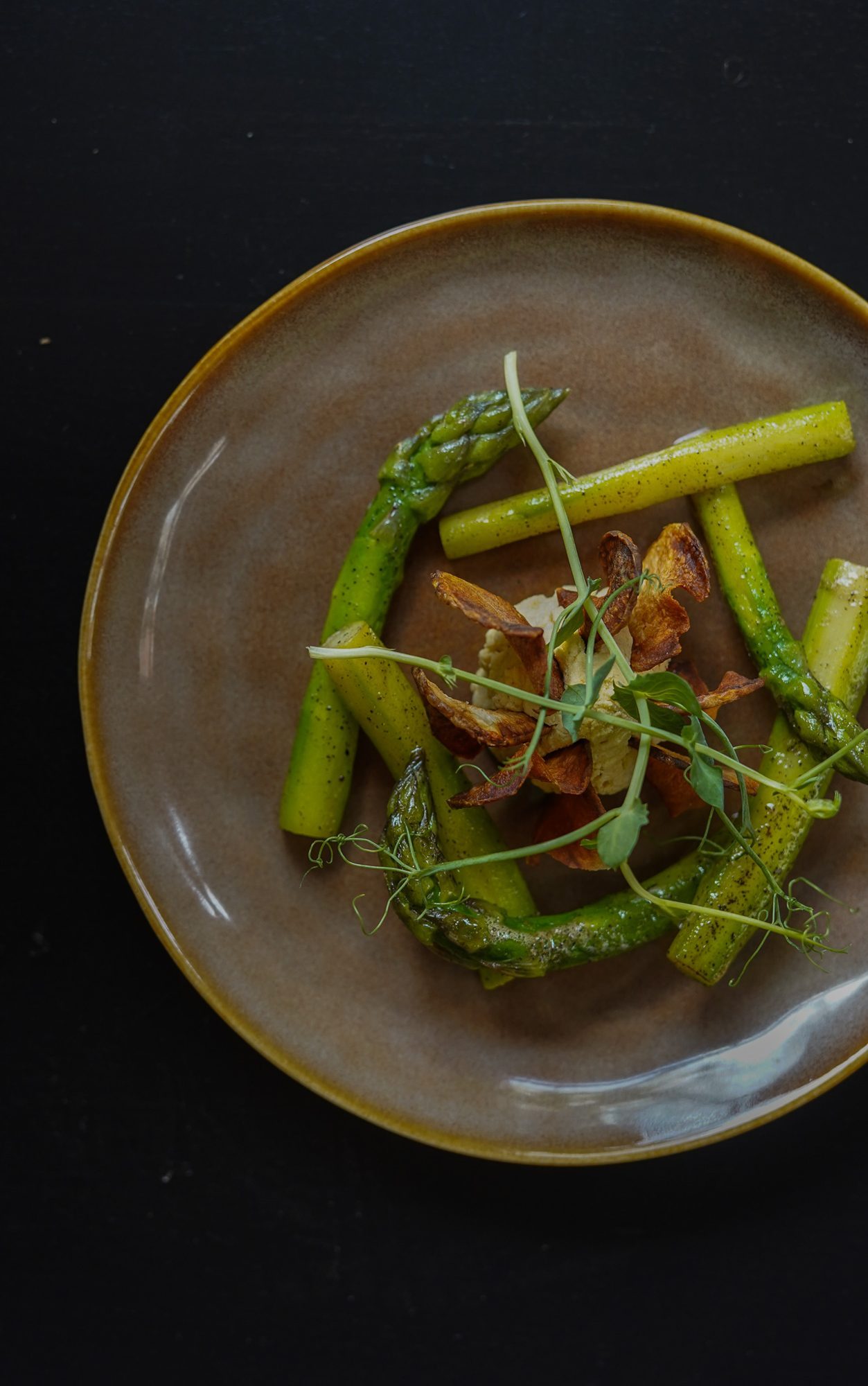 Assiette d’asperges vertes et blanches, chips de légumes et pousses de pois